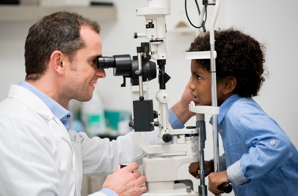Doctor doing eye exam with young kid