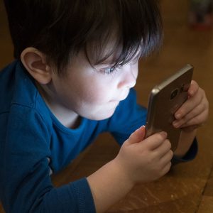 Young boy looking at a phone's screen in the dark
