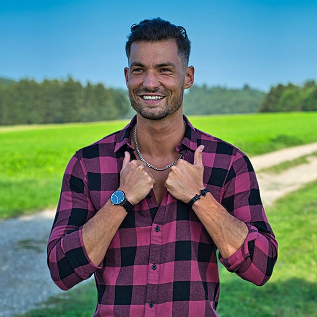 Young man outside adjusting collar of shirt