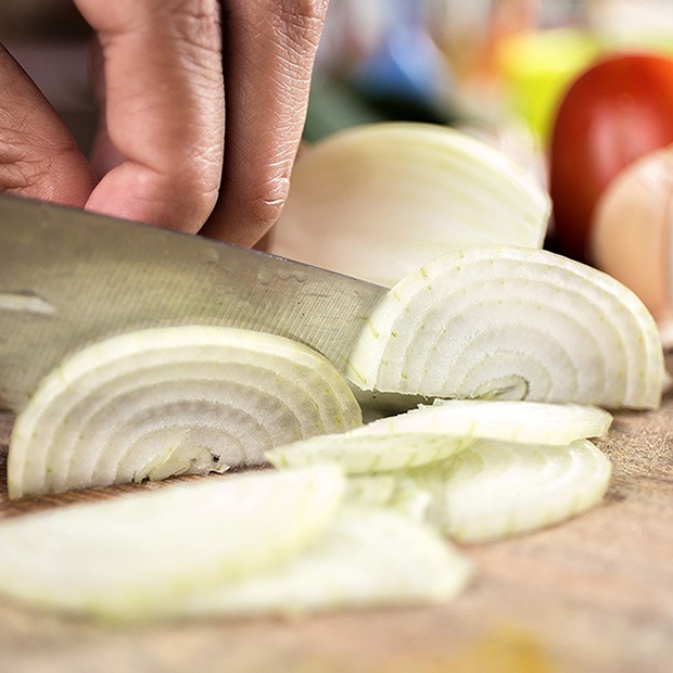 Close up shot of person chopping onions